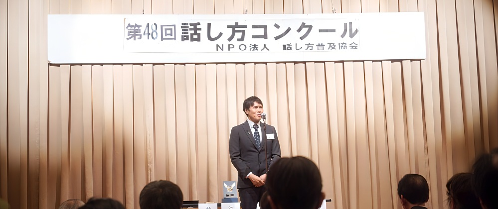 第48回話し方コンクールの舞台でスピーチをする八王子の話し方の会の参加者